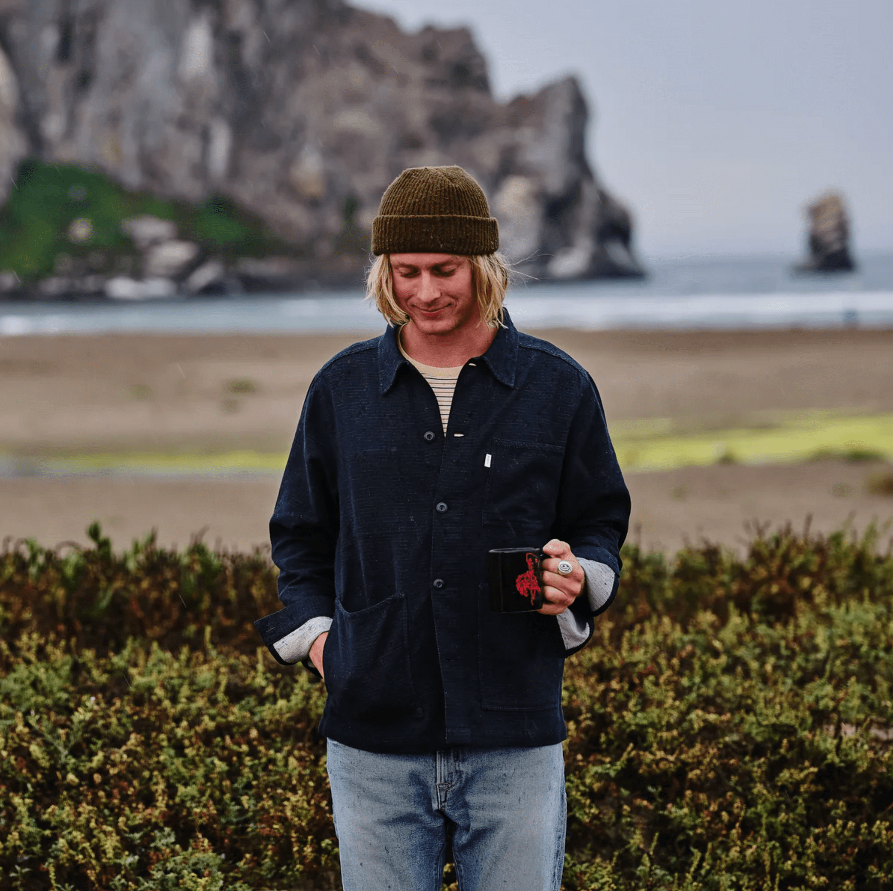 a guy drinking coffee at the beach