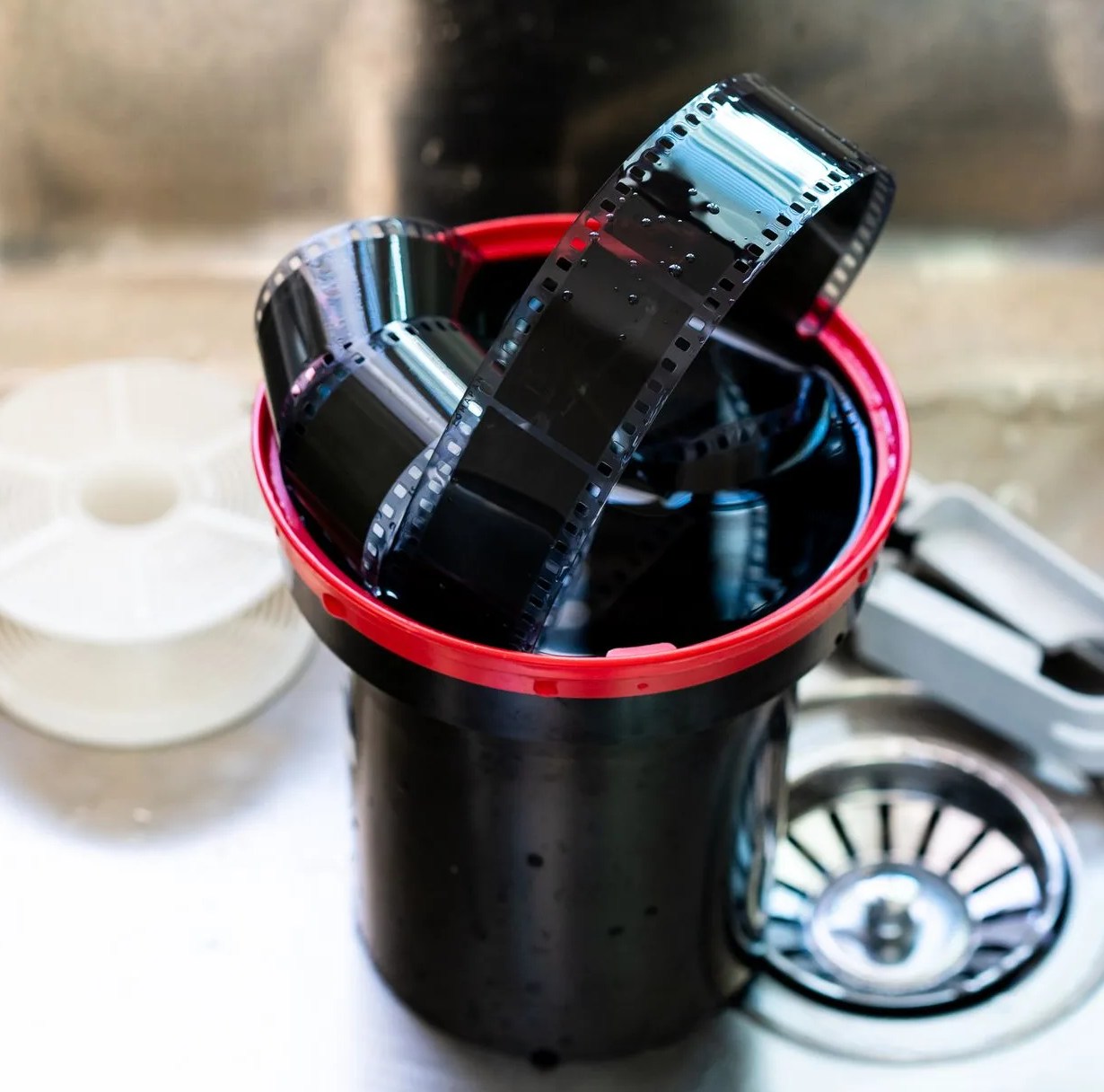 film developing tank with 135 photographic film in a tank after developed close up