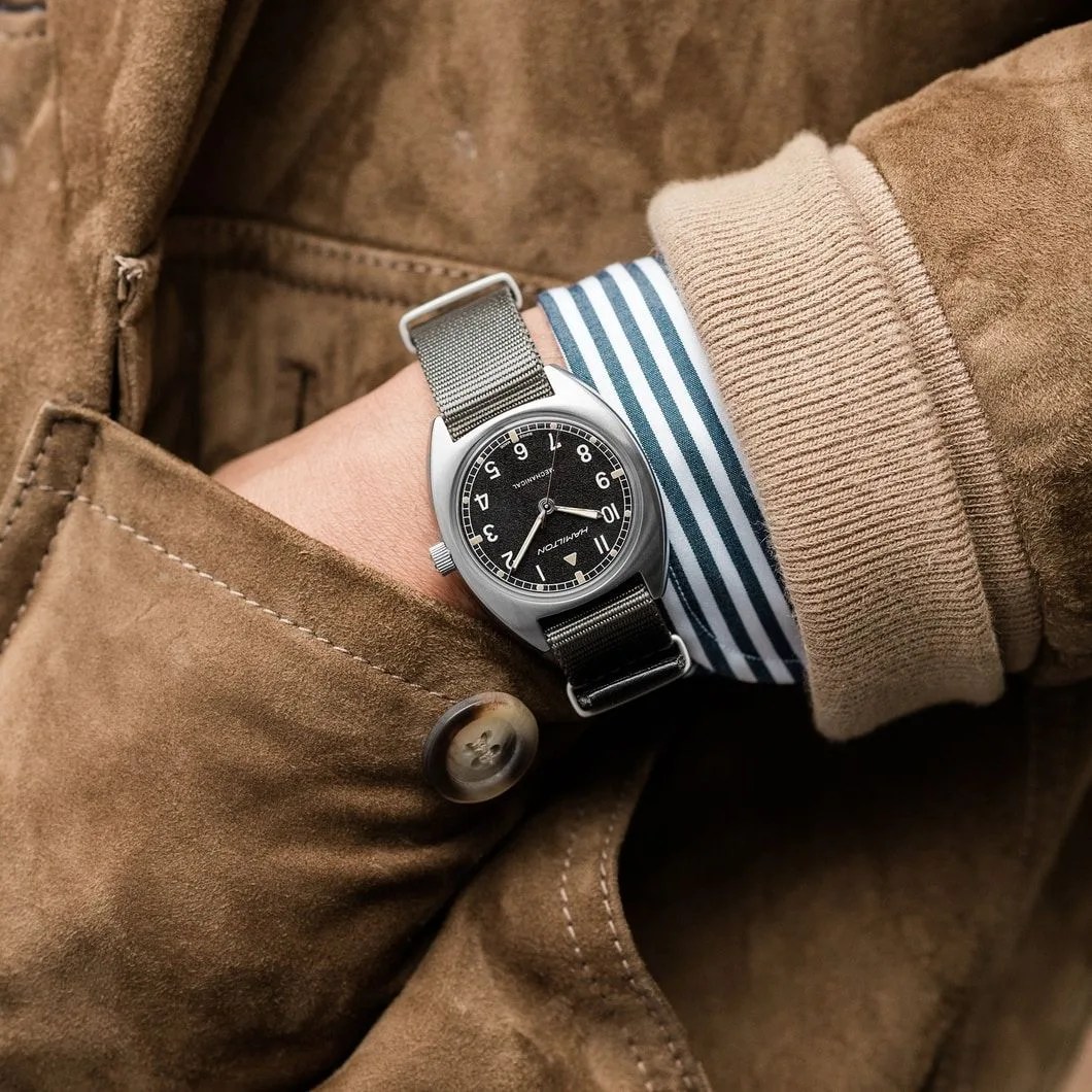 vintage style watch on wrist with leather coat