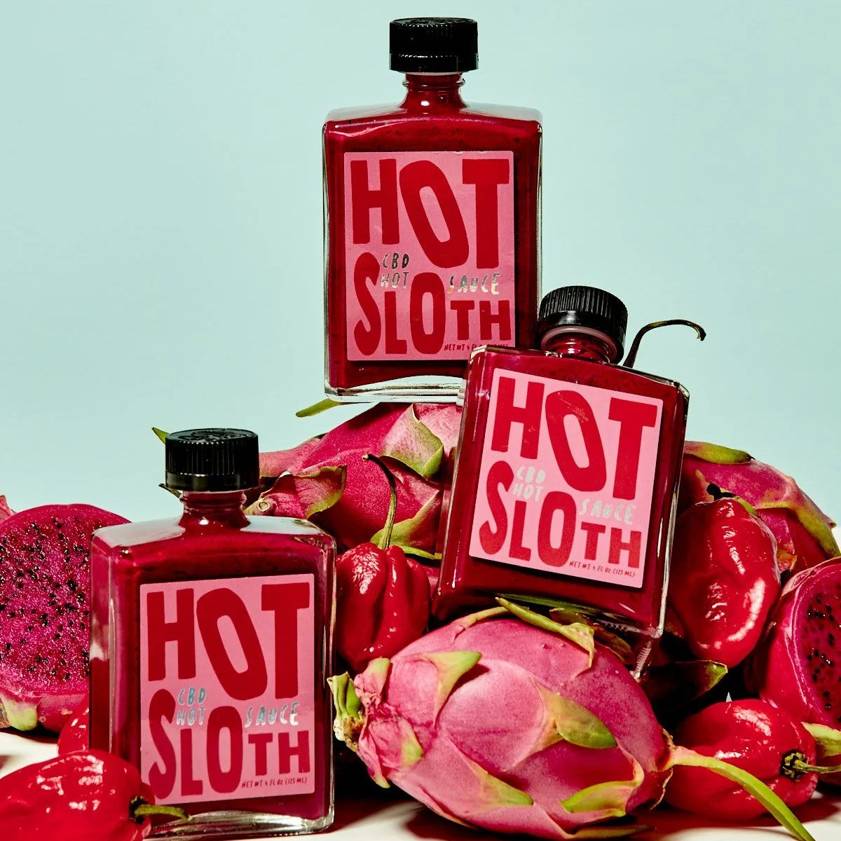 hot sloth bottles stacked on dragon fruit and peppers