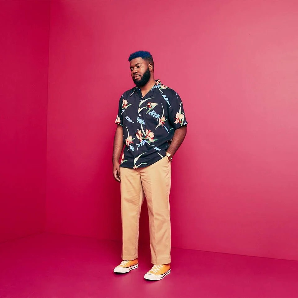 man wearing hawaiian shirt, khakis and yellow sneakers