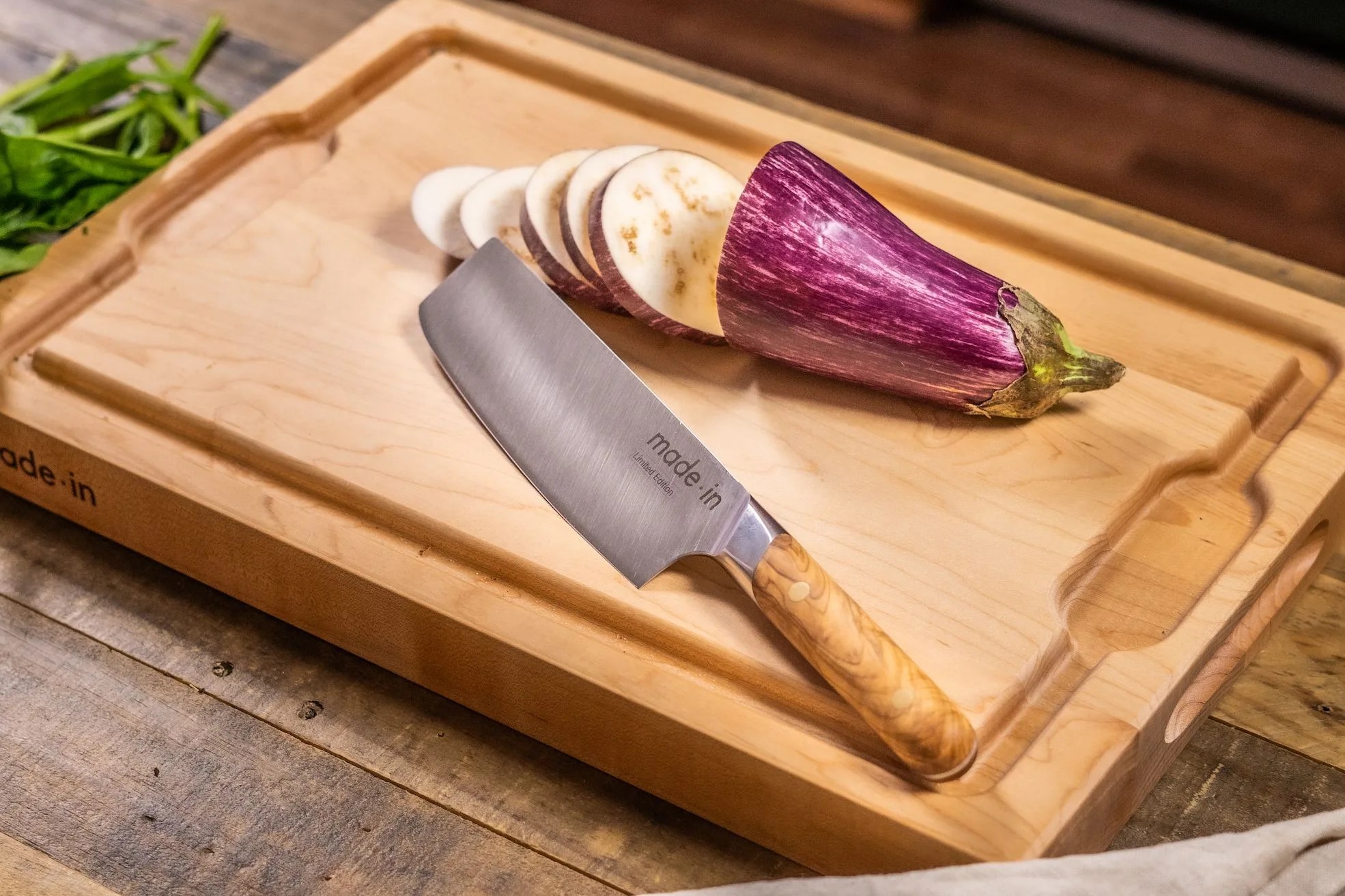 knife on cutting board next to sliced eggplant