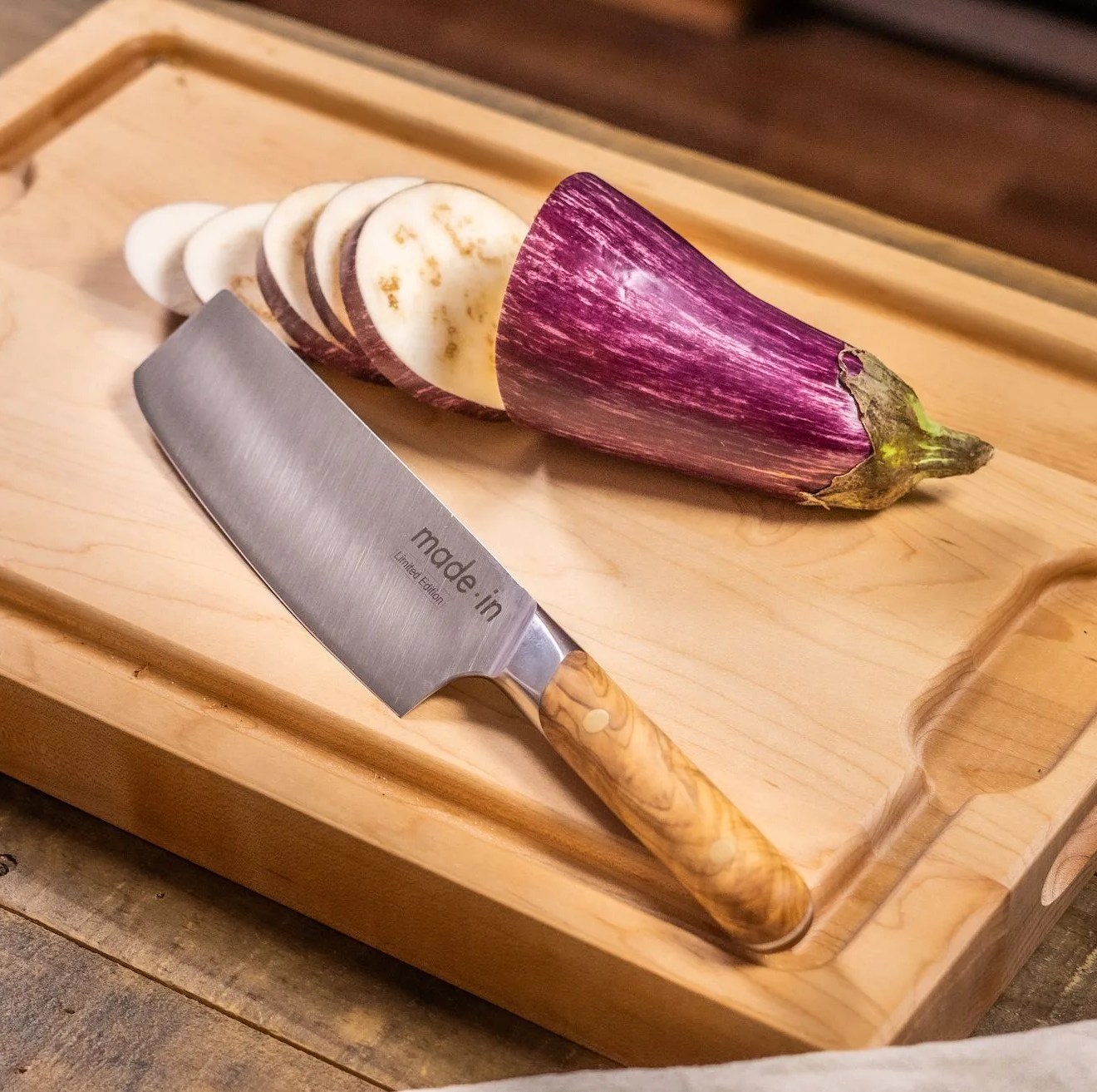 knife on cutting board next to sliced eggplant