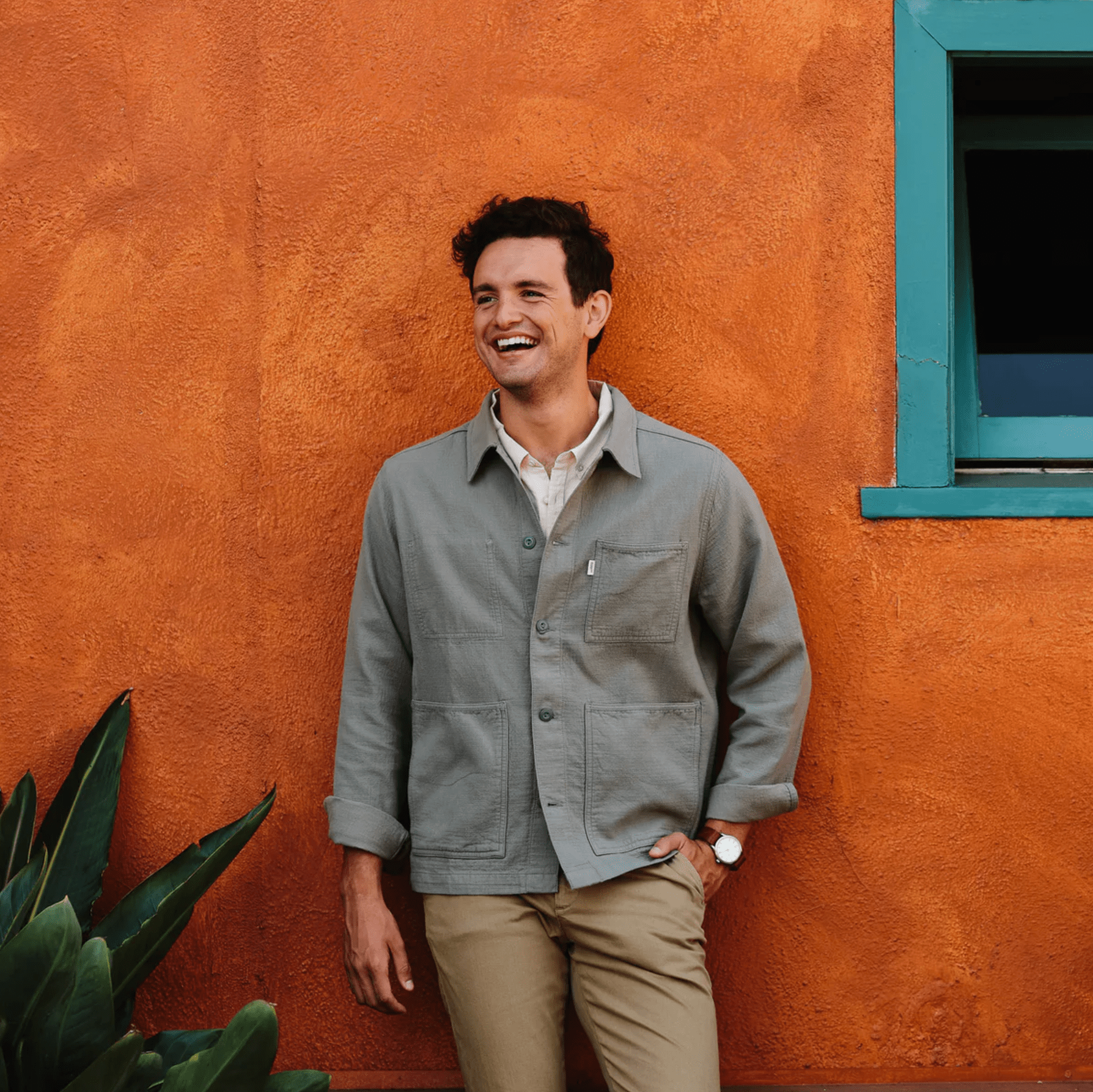 a model wearing a chore coat on a clay wall