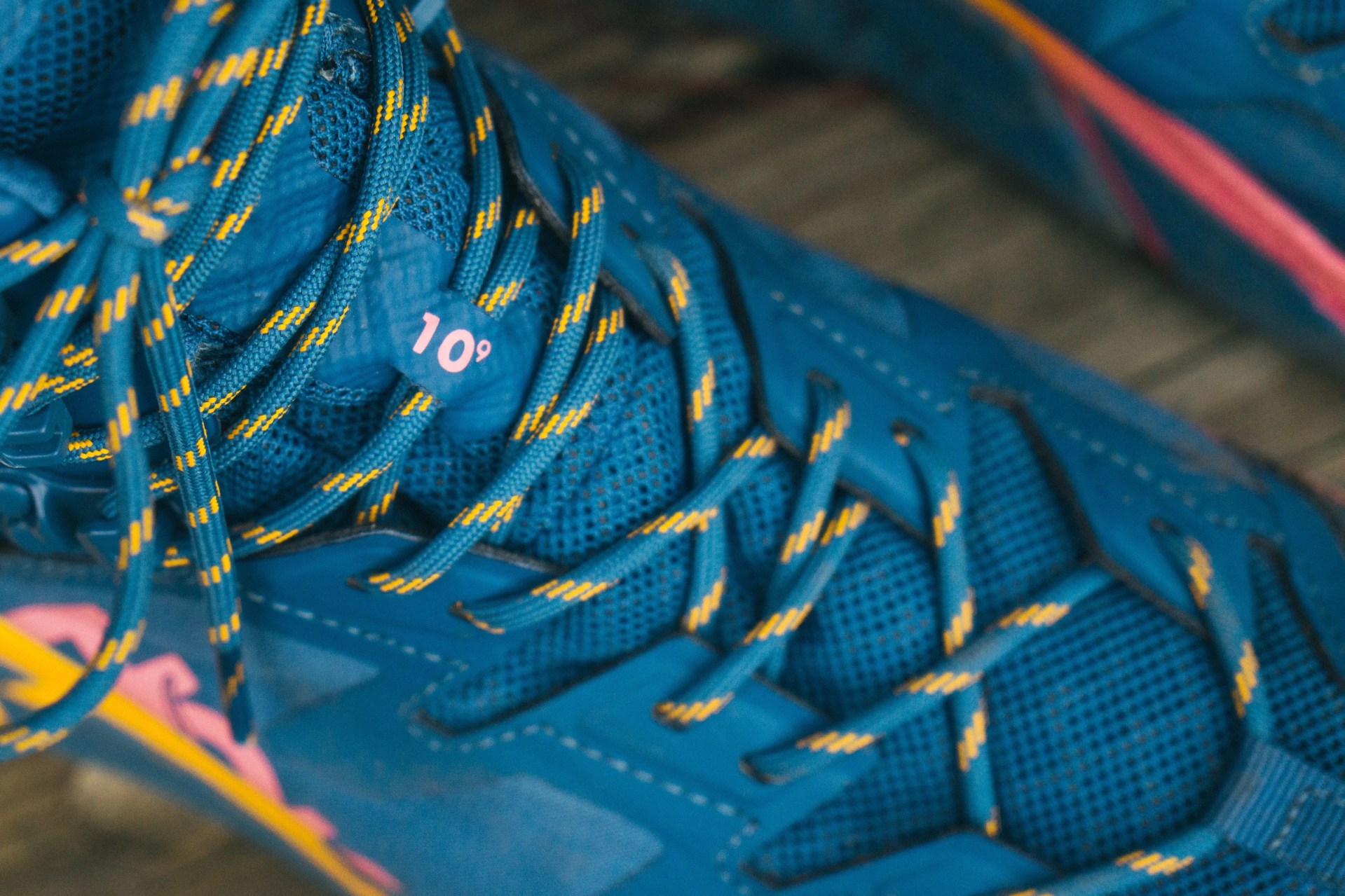 a close up of the laces of a blue hiking boot