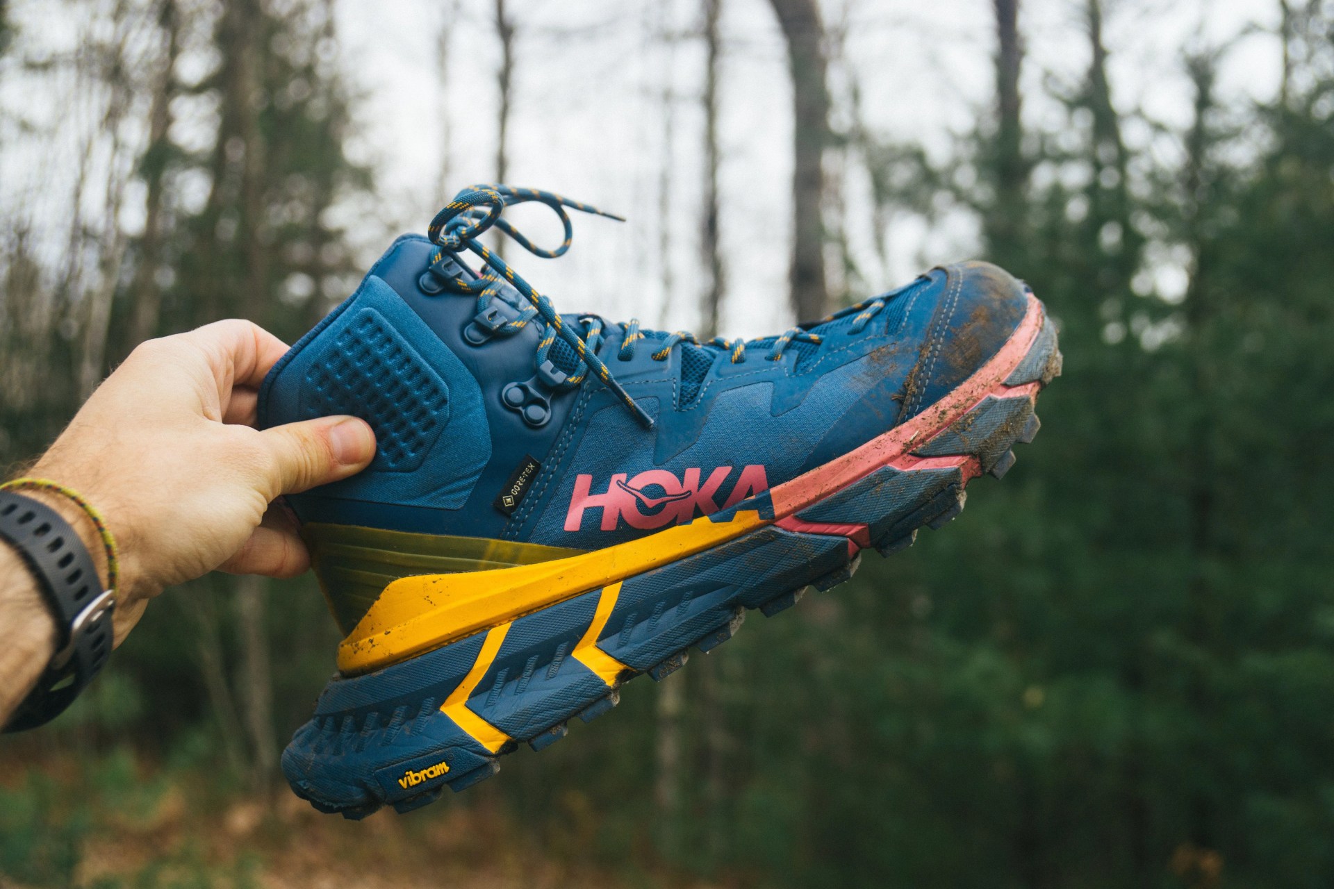 a blue hiking boot with orange and pink highlights