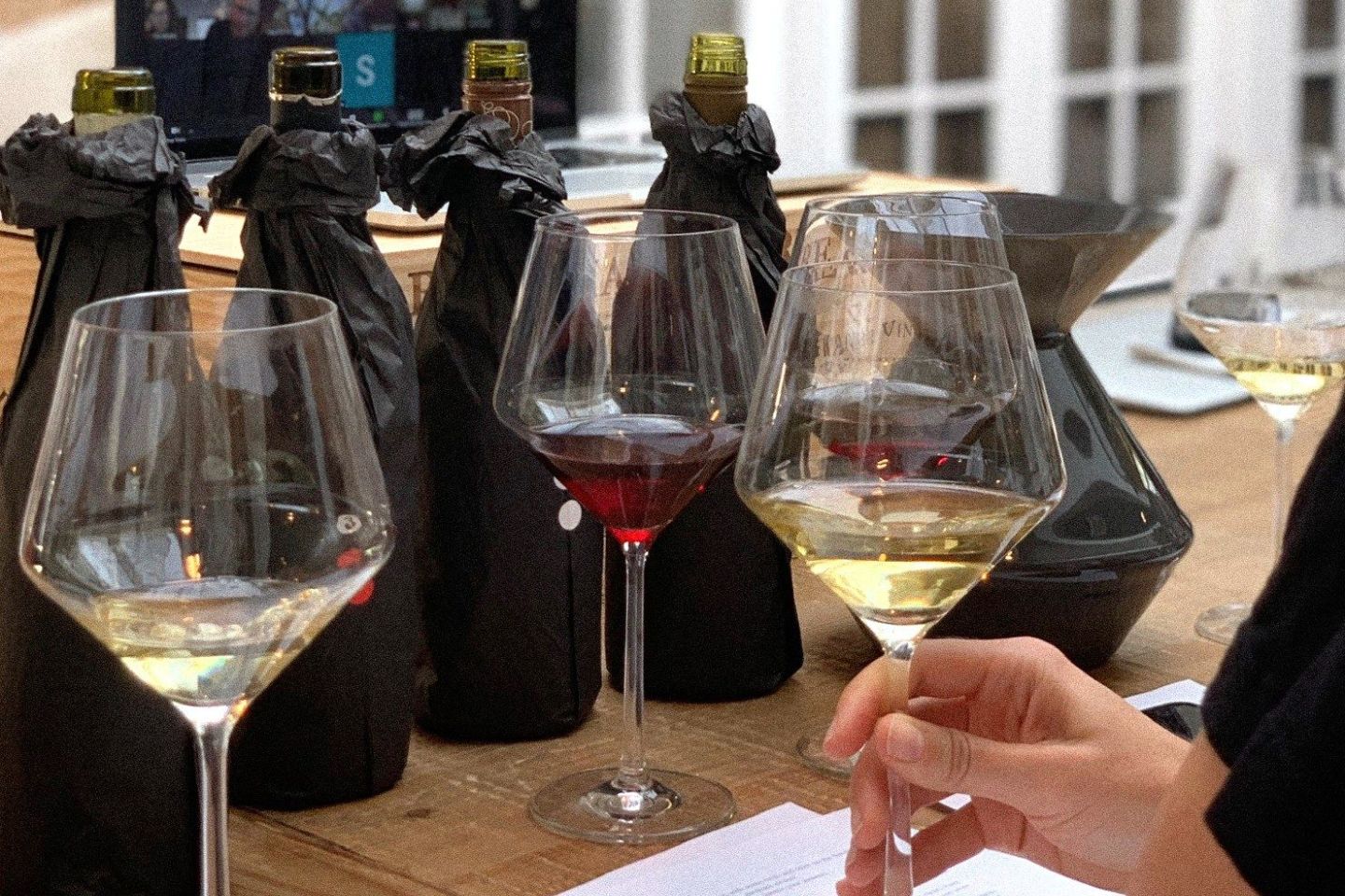 wrapped bottles of wine and wine filled wine glasses