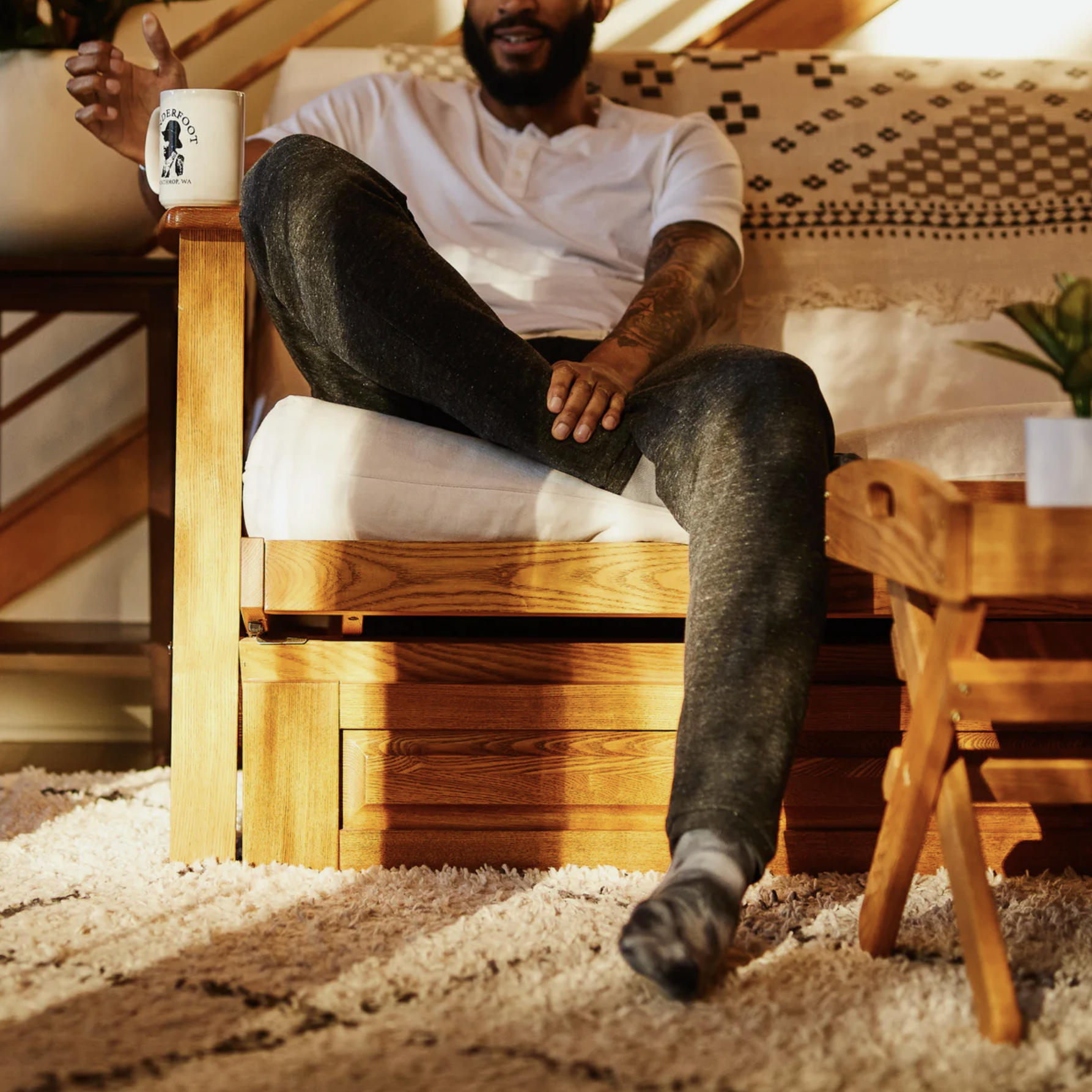 a model wearing sweatpants on a couch
