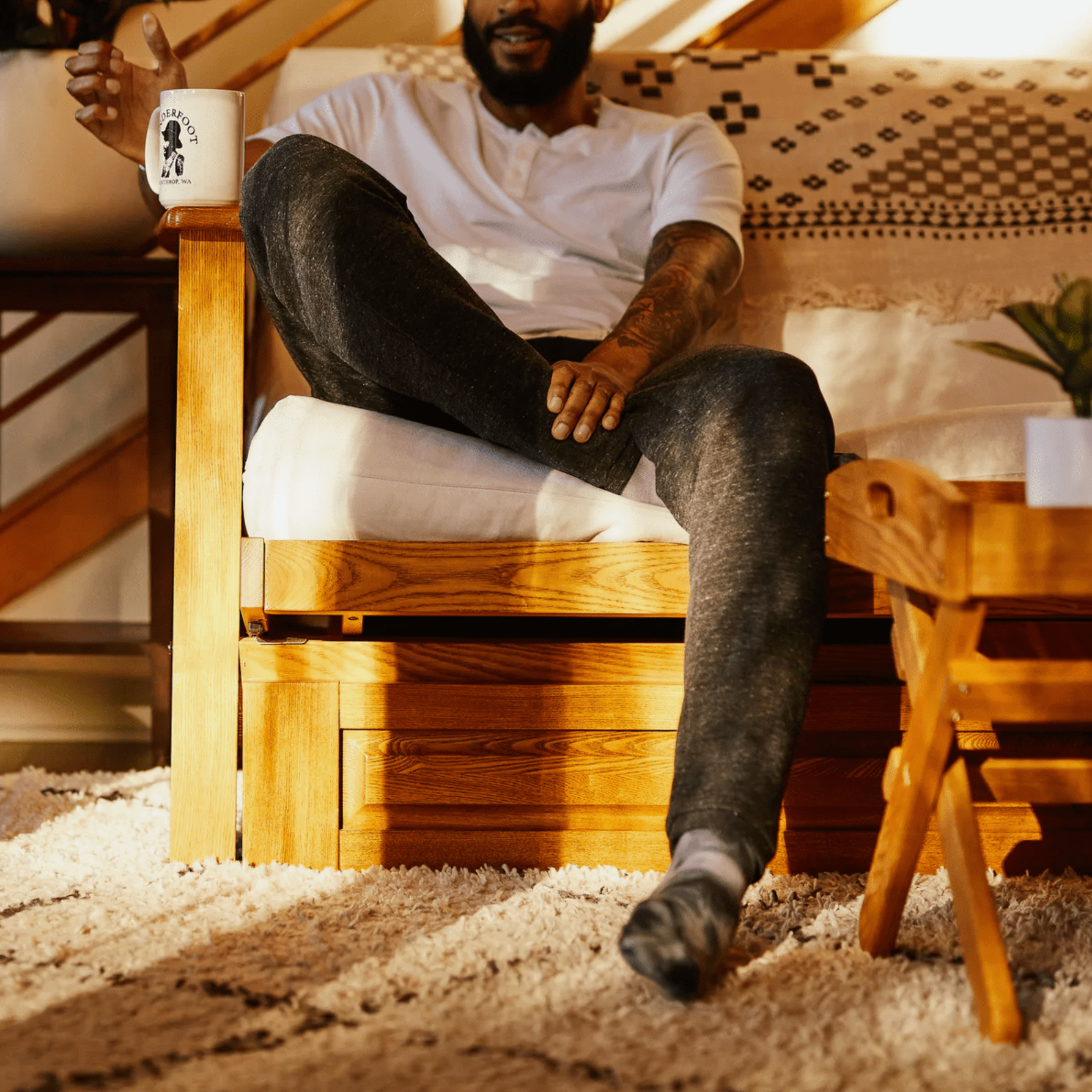 a model wearing sweatpants on a couch