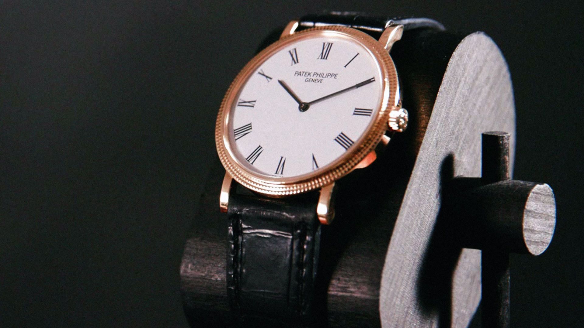 gold patek phillipe calatrava wristwatch on a black leather strap