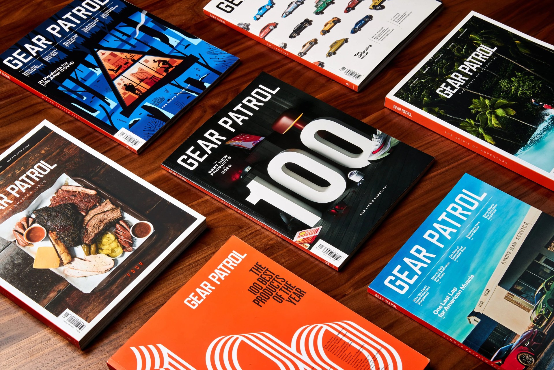 several copies of gear patrol magazine laying on a walnut wood table