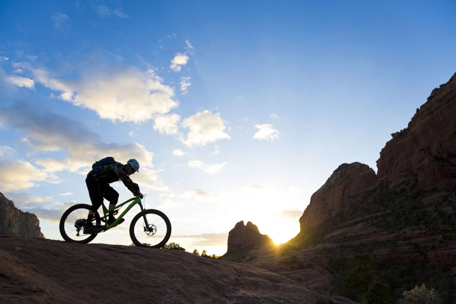 a man rides his enduro style mountain bike at sunset in sedona, arizona, usa