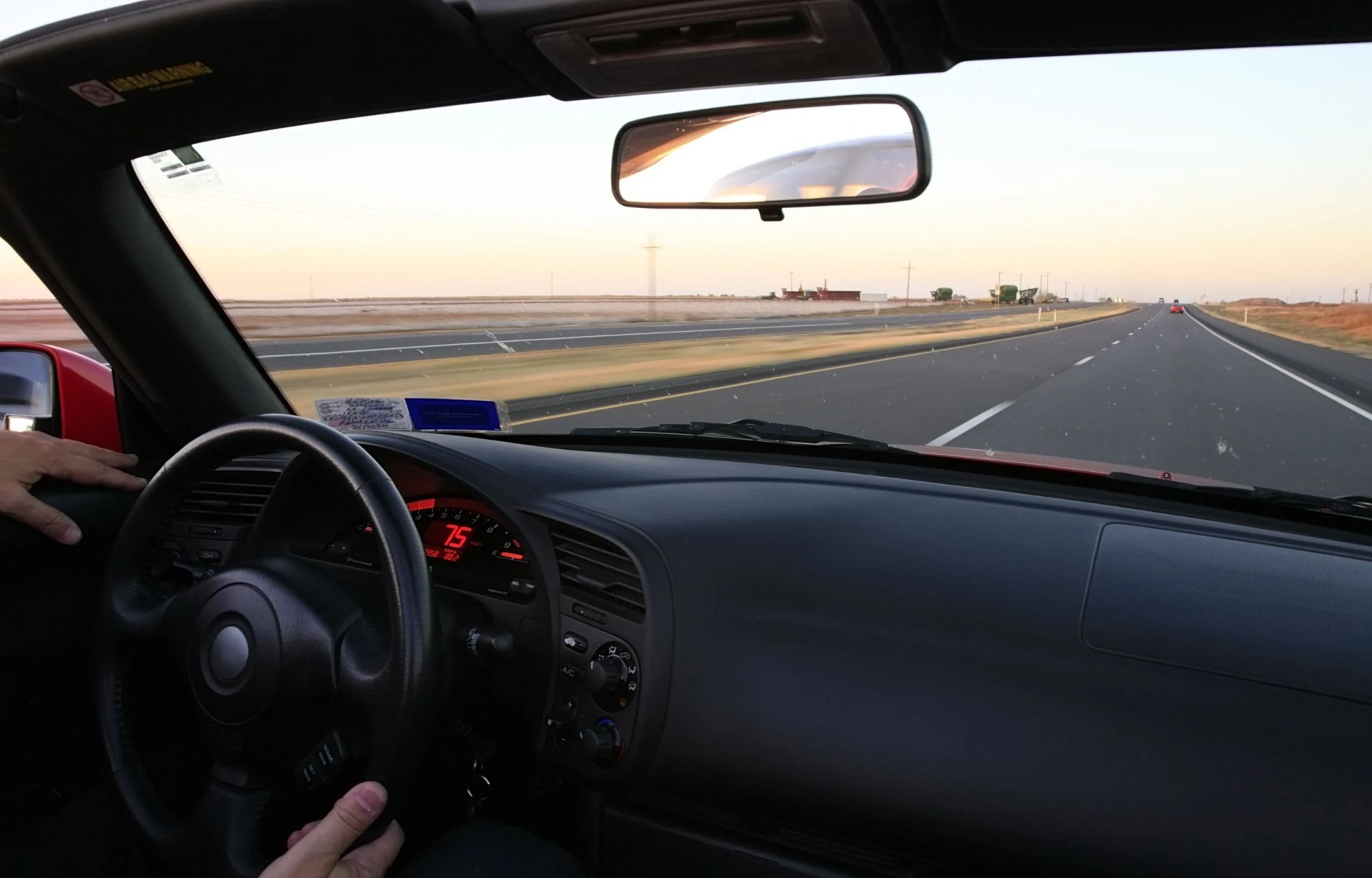 cruising at 75 mph in a red convertible sports car