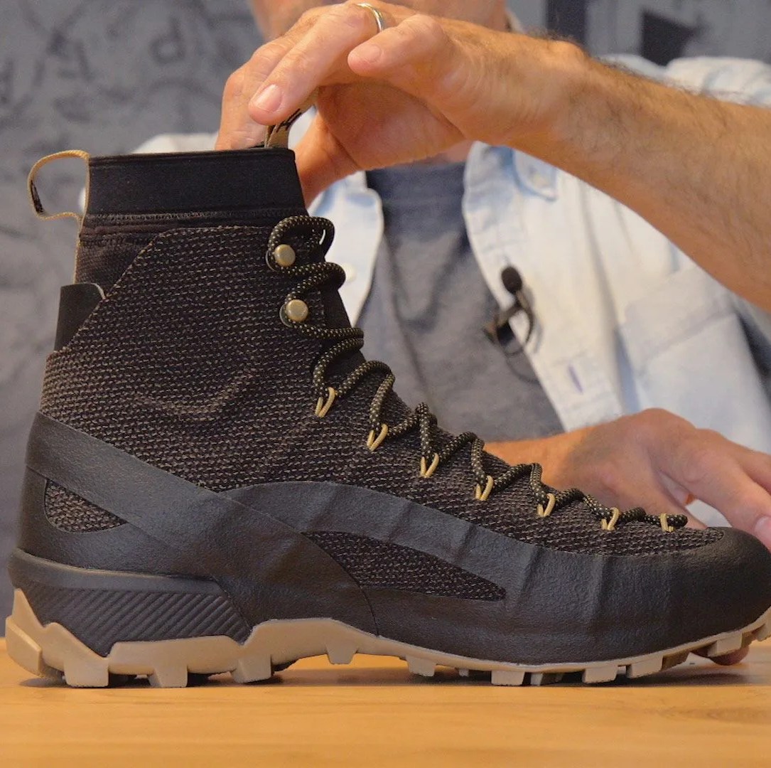 a black full sized hiking boot made of kevlar on a table