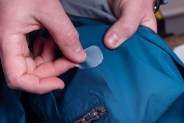 a person repairing a hole in a jacket