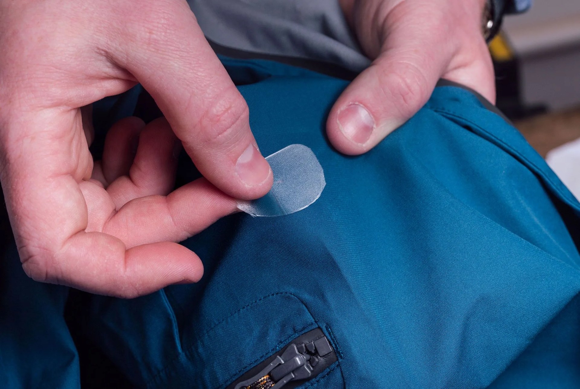 a person repairing a hole in a jacket
