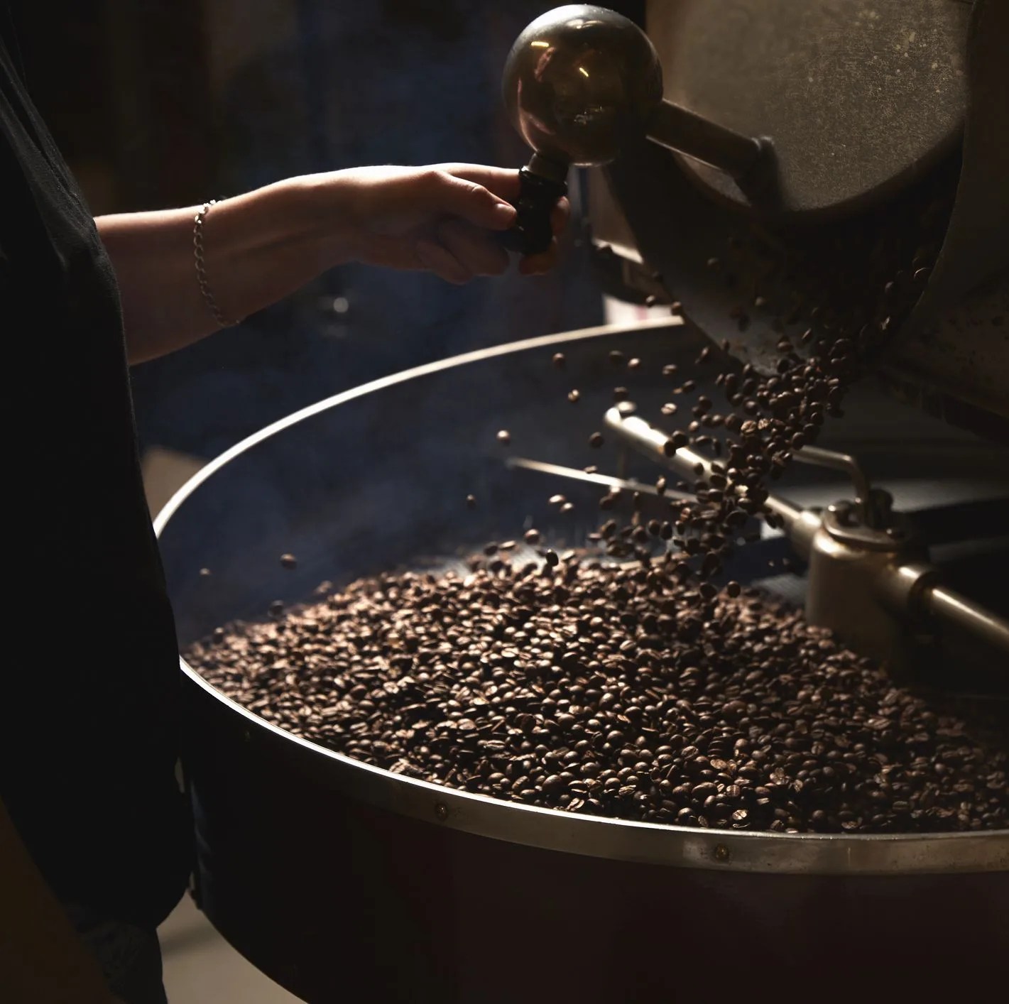 a coffee shop a metal drum with roasting coffee beans and a central paddle