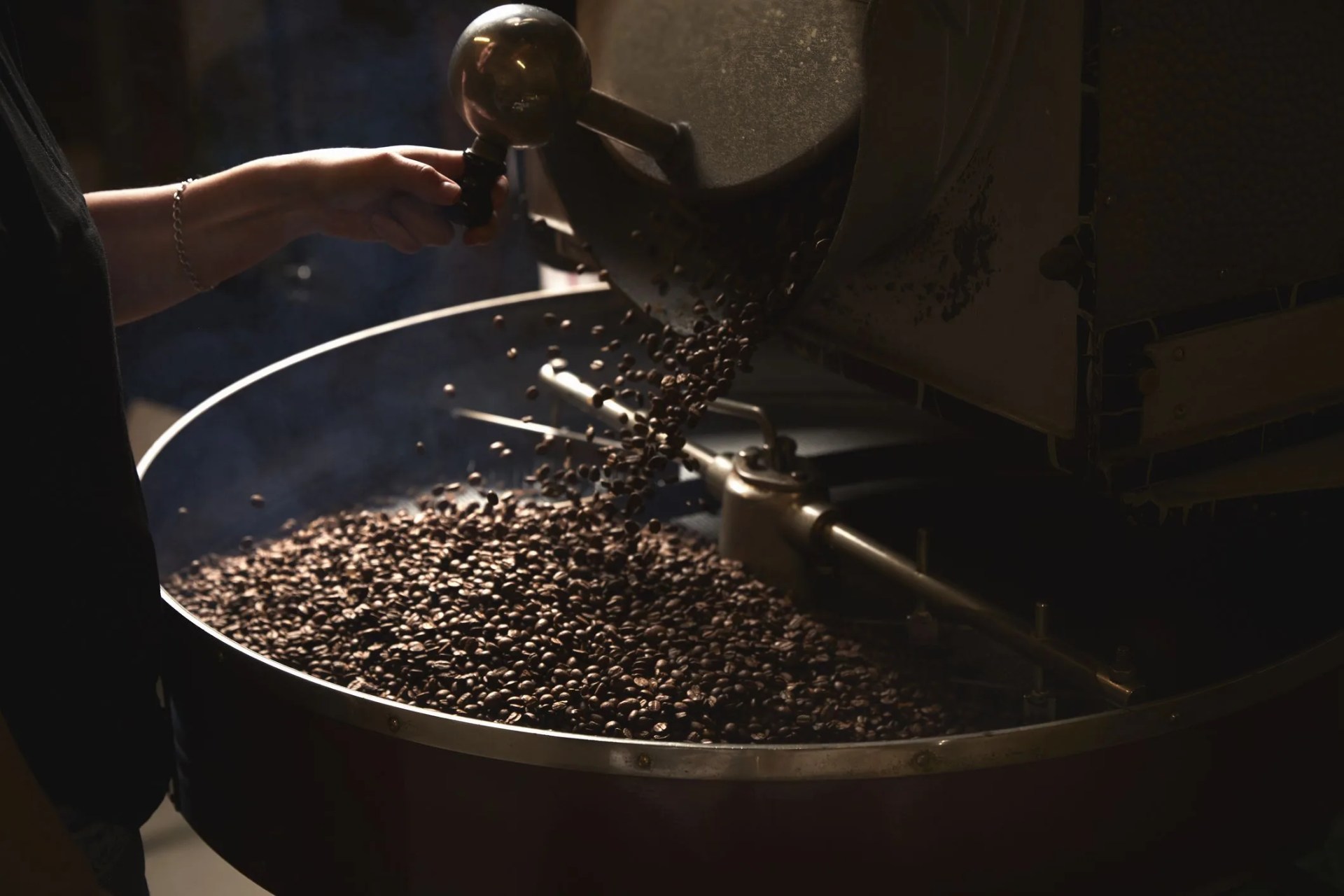 a coffee shop a metal drum with roasting coffee beans and a central paddle