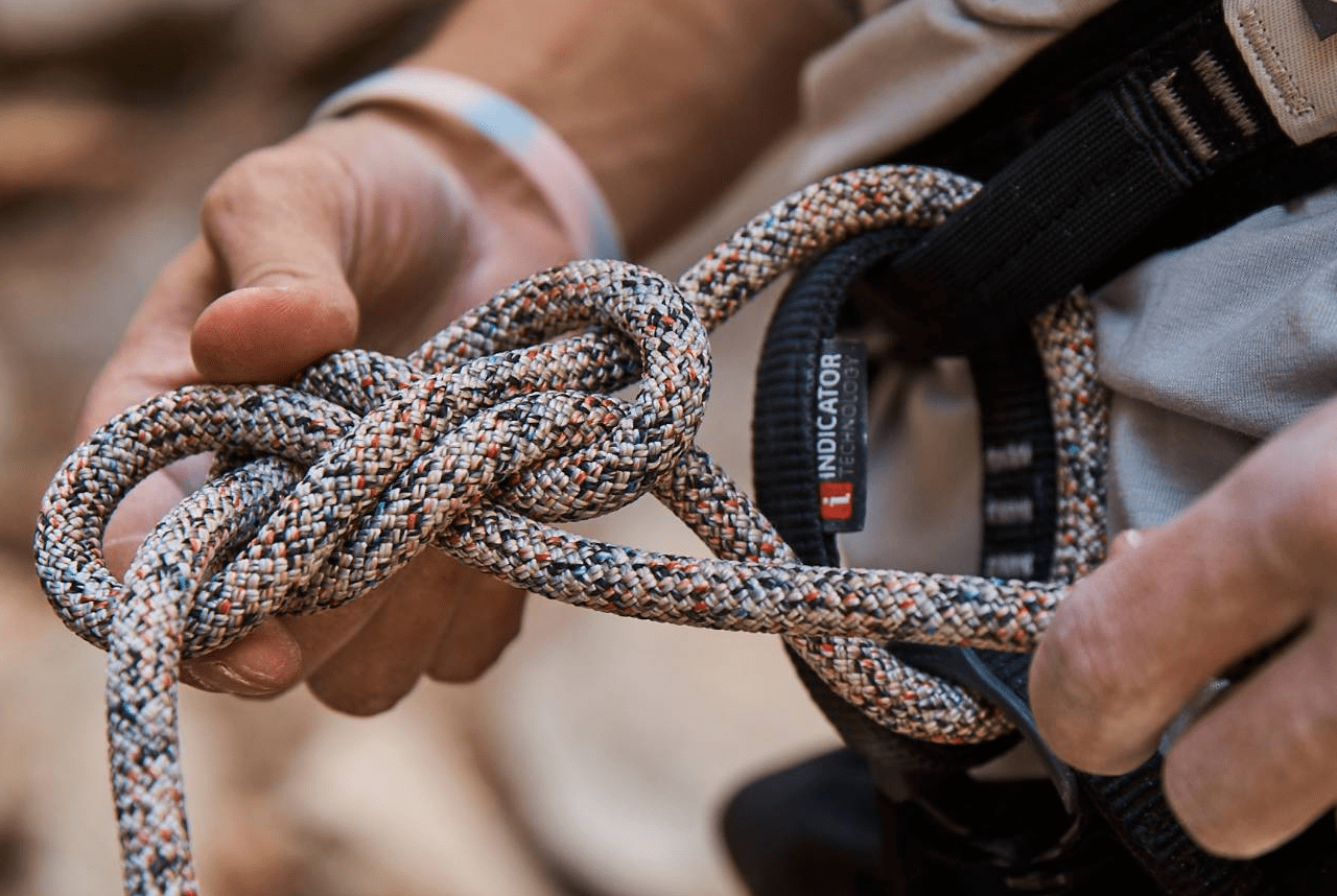 a man tying a colorful climbing rope