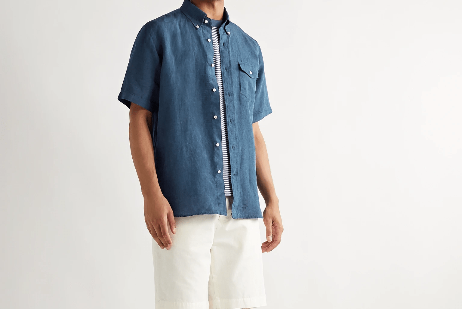 model wearing blue short sleeve shirt and white shorts