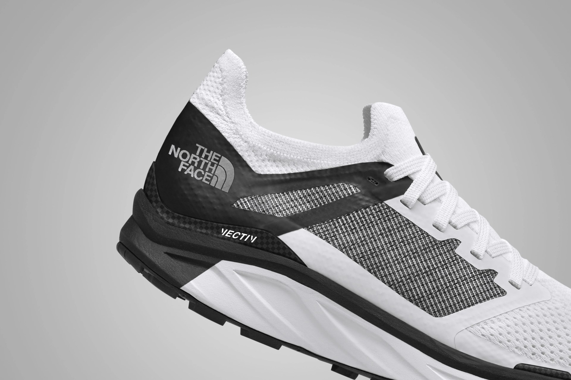the heel of a white and black trail running shoe