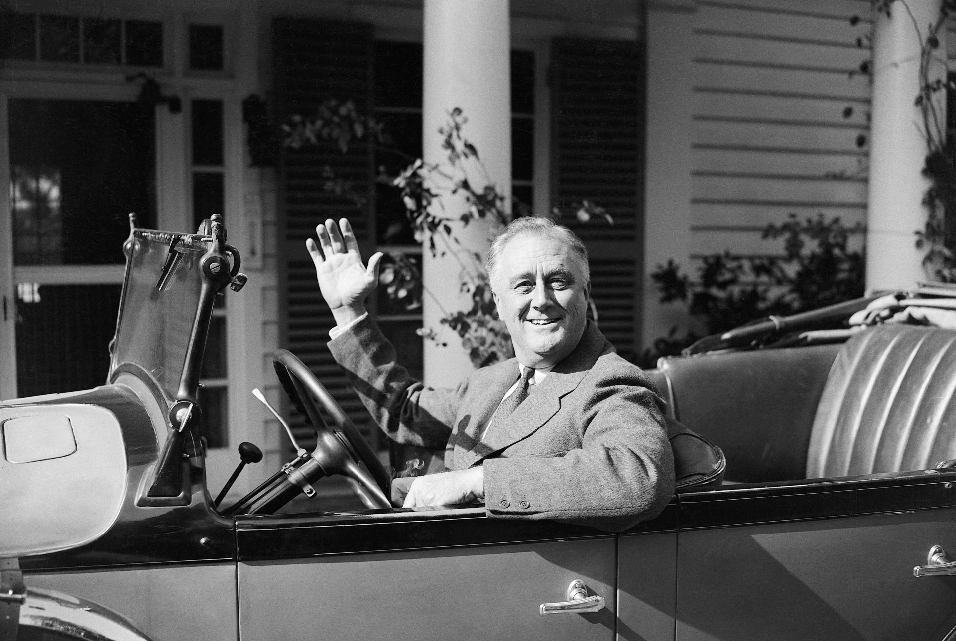 president franklin delano roosevelt waving from a convertible