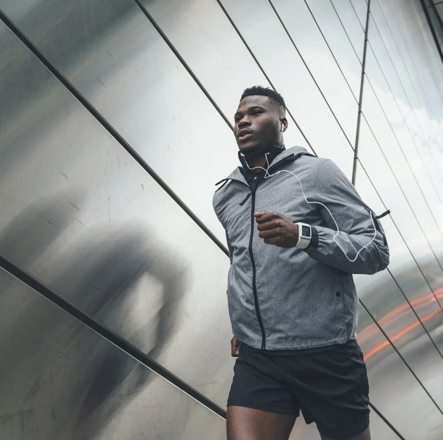 young man running along building front