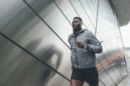young man running along building front