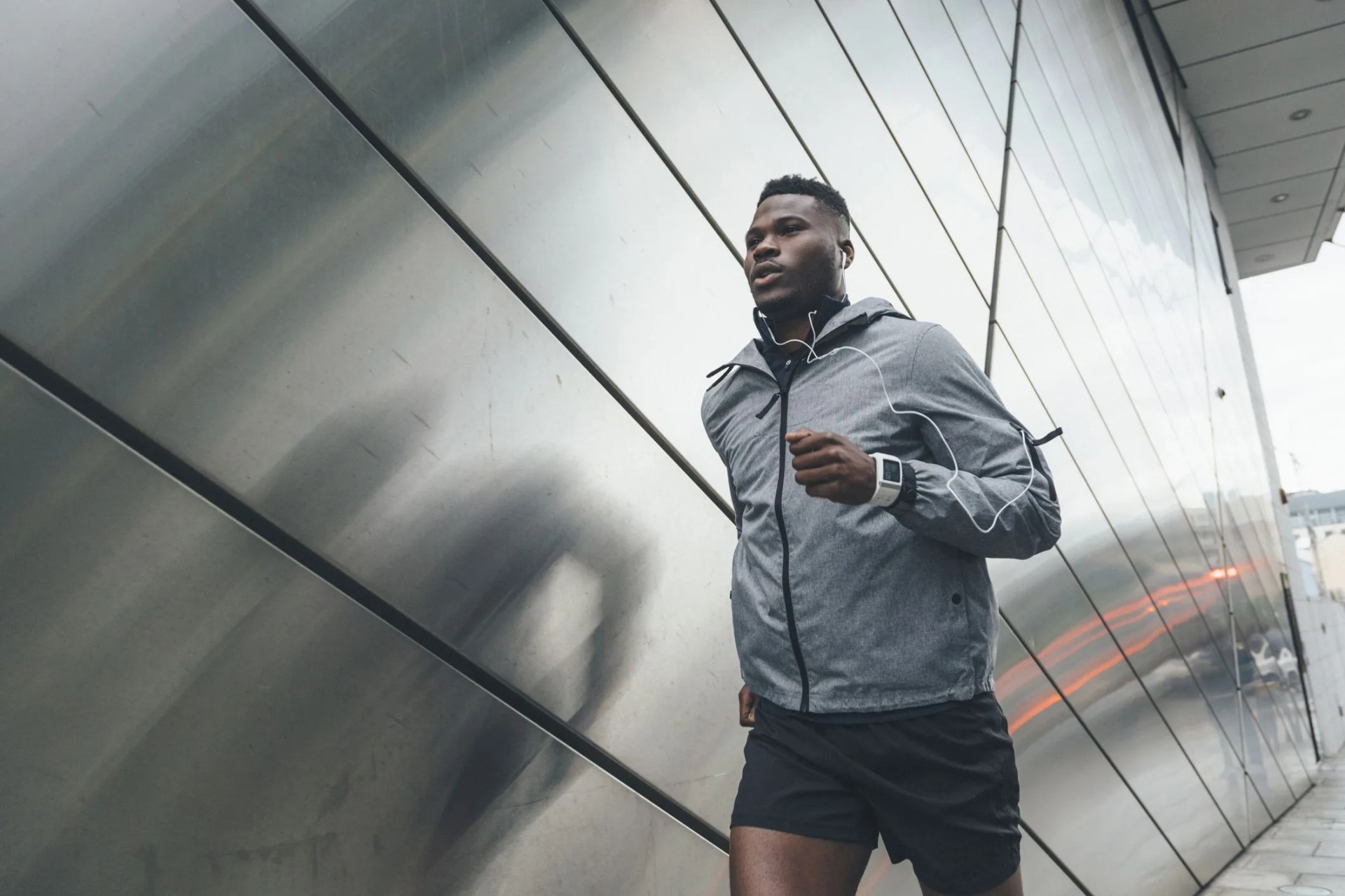 young man running along building front