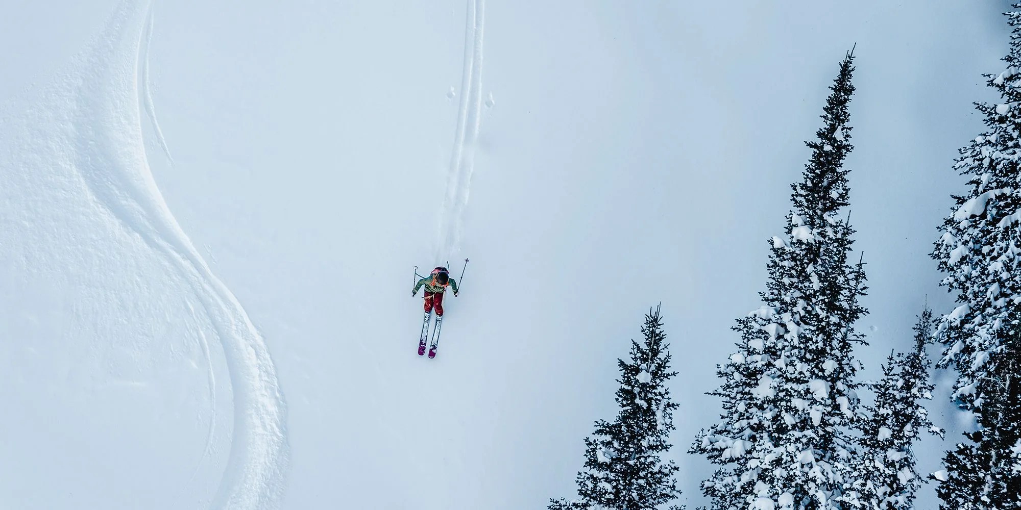 man wearing backcountry items skiing on a snowy hill