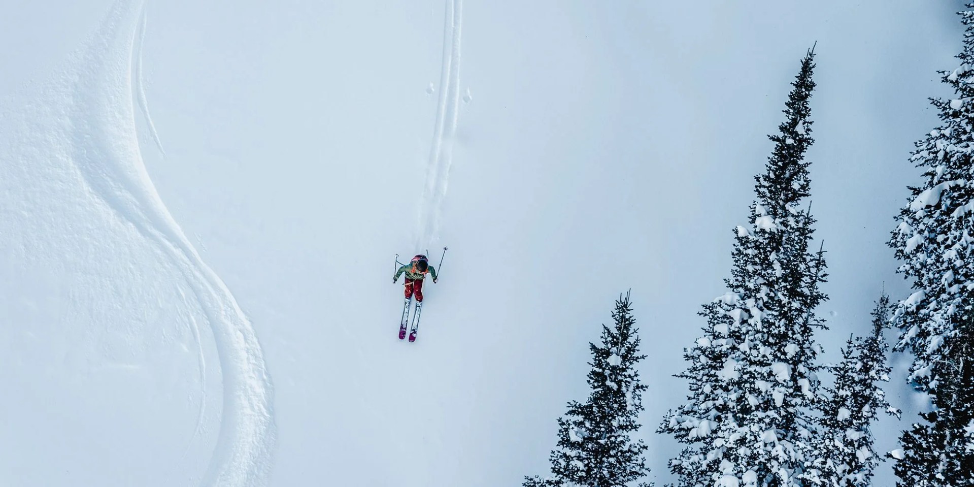 man wearing backcountry items skiing on a snowy hill