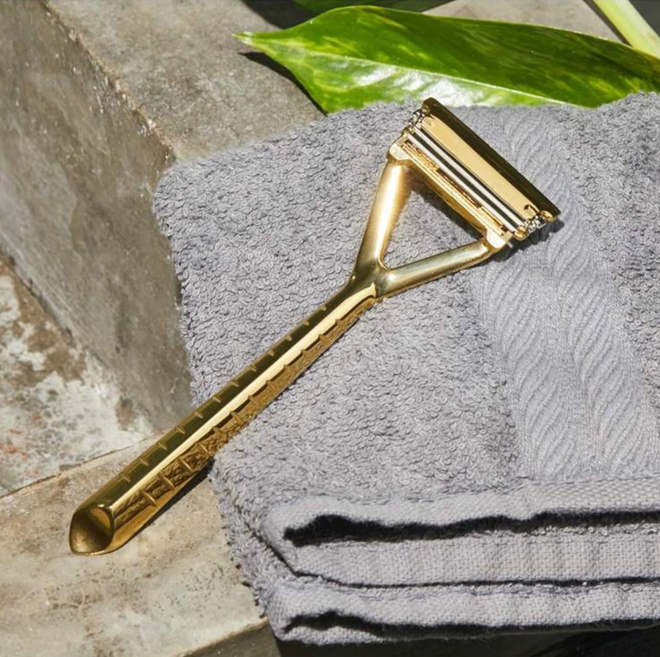 gold leaf razor laying against gray towel