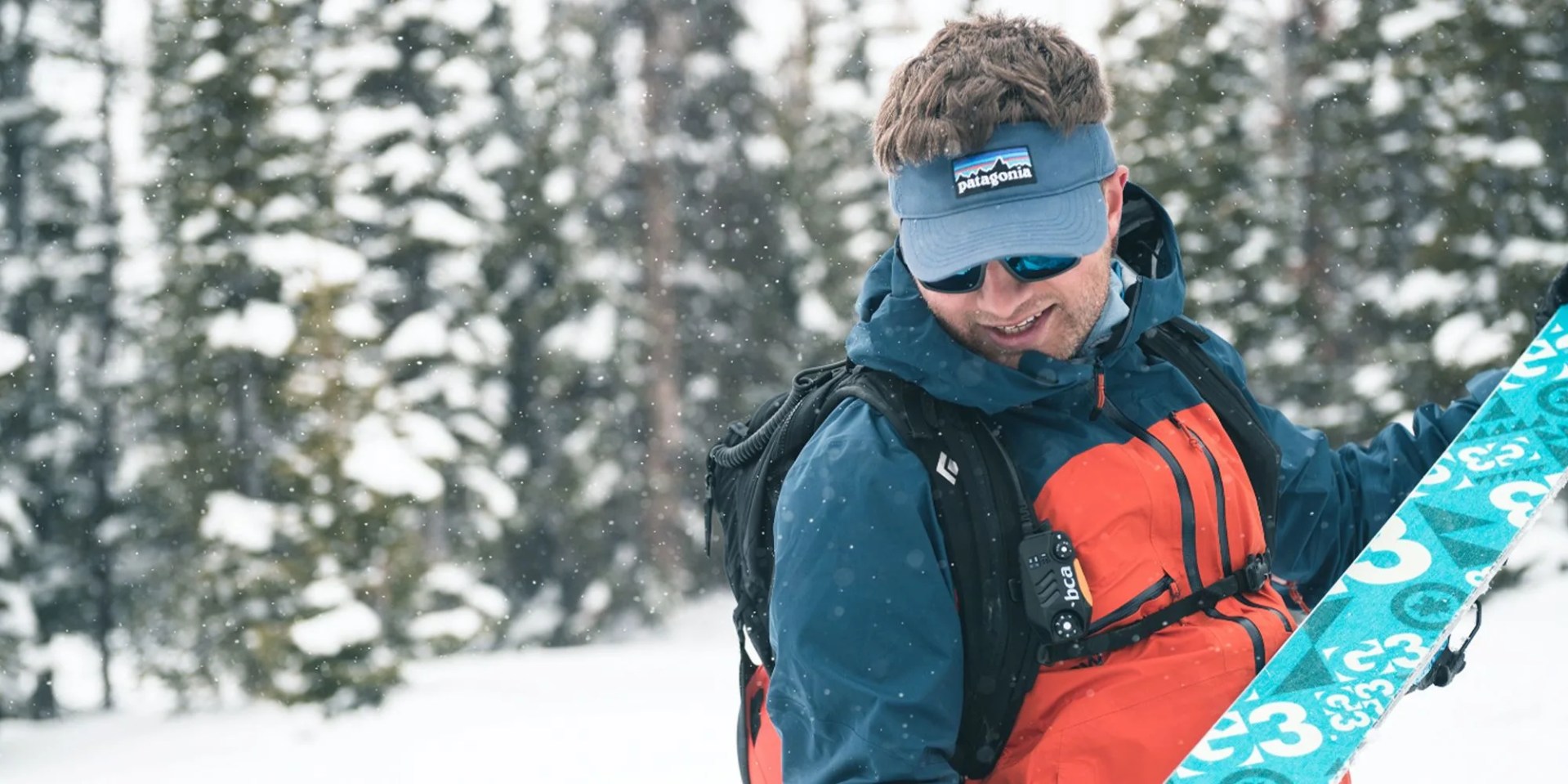 man wearing winter gear holding ski