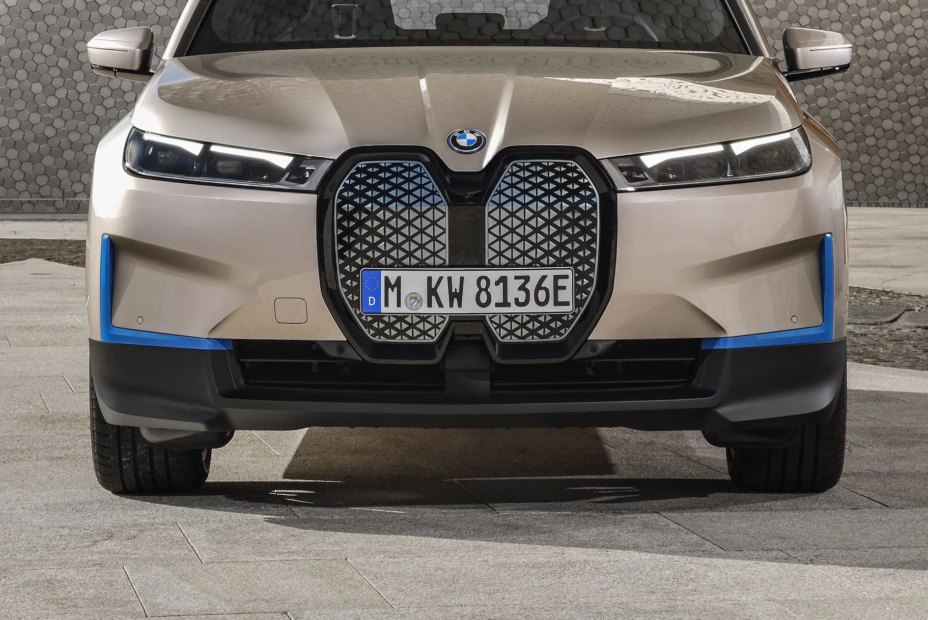 bmw ix on a stone driveway in front of a modernist building