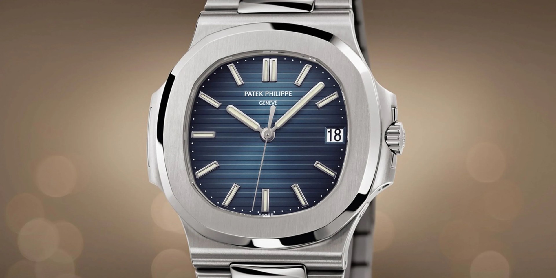 Patek Philippe Steel Nautilus ref. 5711 shown against a tannish background with bokeh light bubbles. 