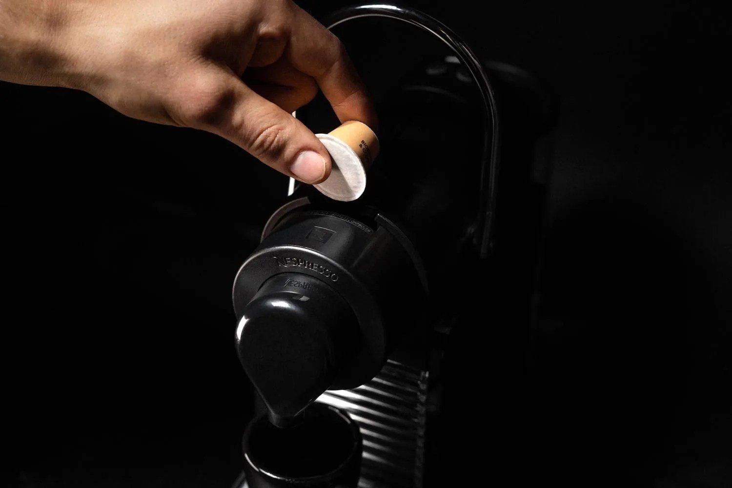 hand placing coffee pod into machine