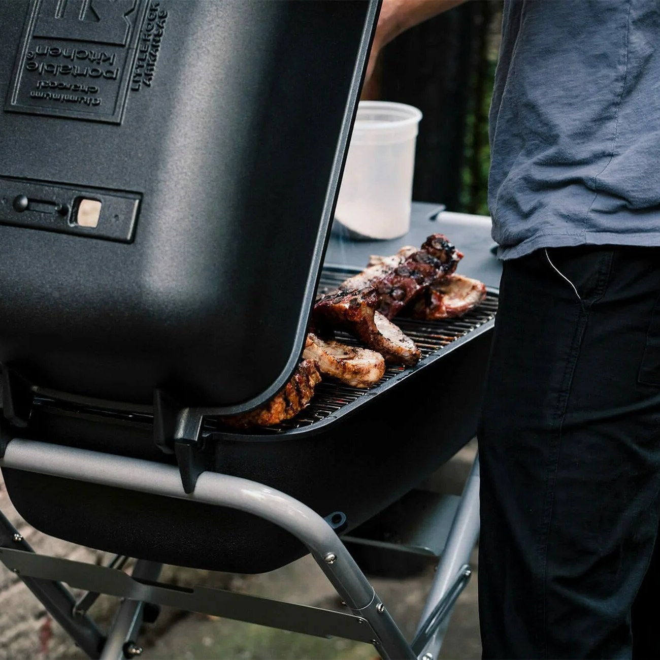 man cooking on a charcoal grll