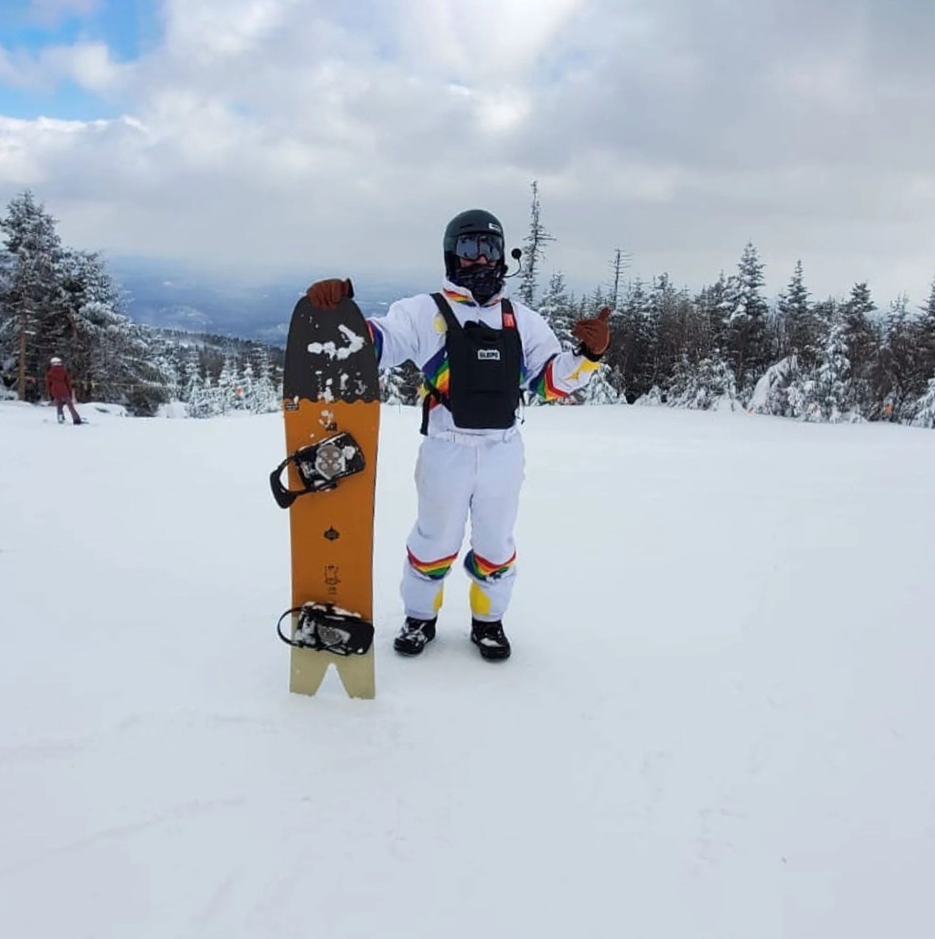 man holding snowboard on snowy mountain