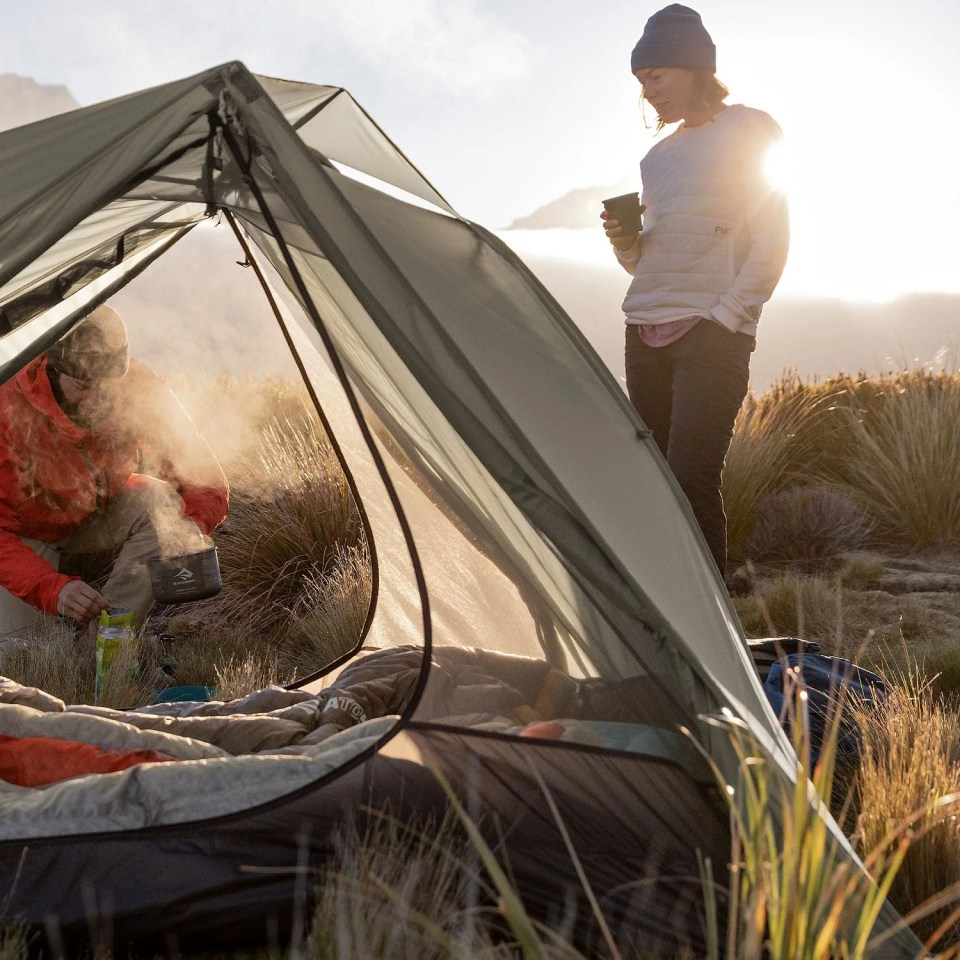 two people camping with a gray tent
