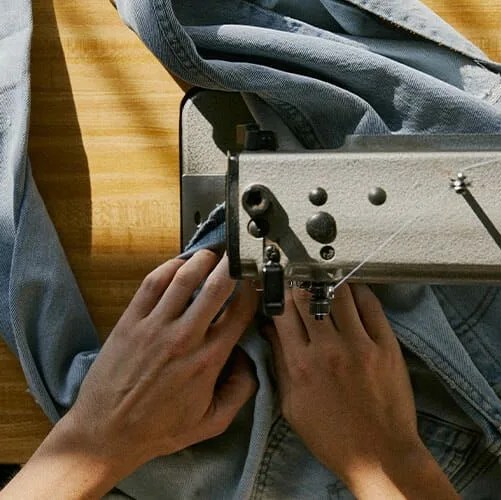 hands sewing jeans