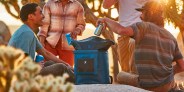 people outside pulling cans out of a cooler