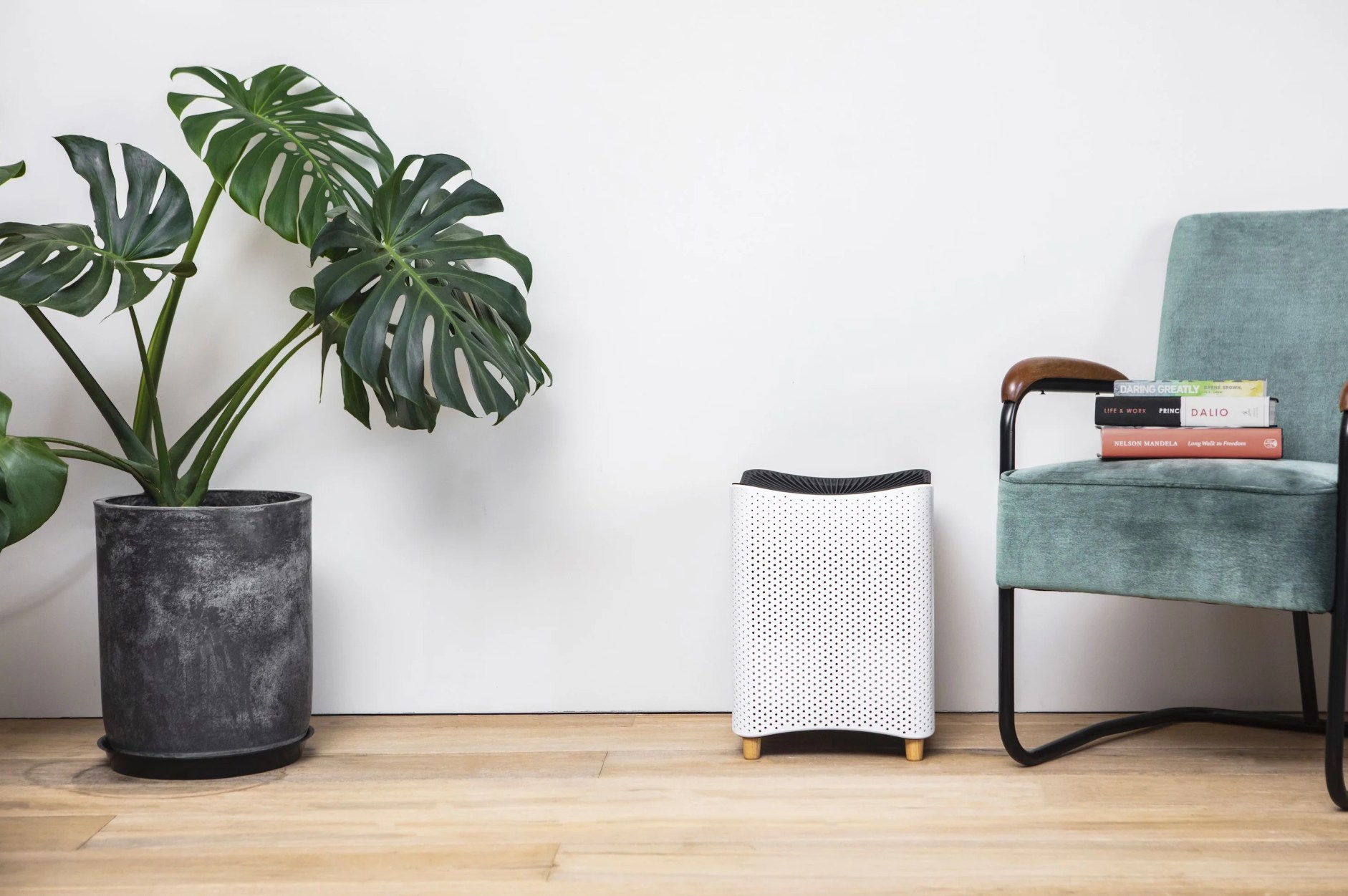 air purifier in room next to chair and plant