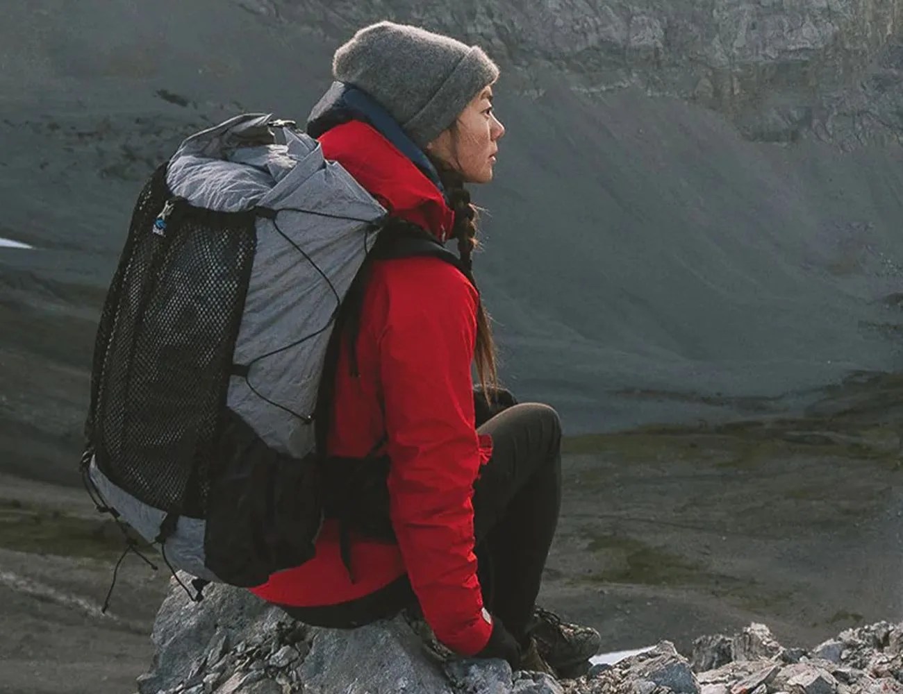 woman sitting on top of a mountain wearing a zpacks backpack