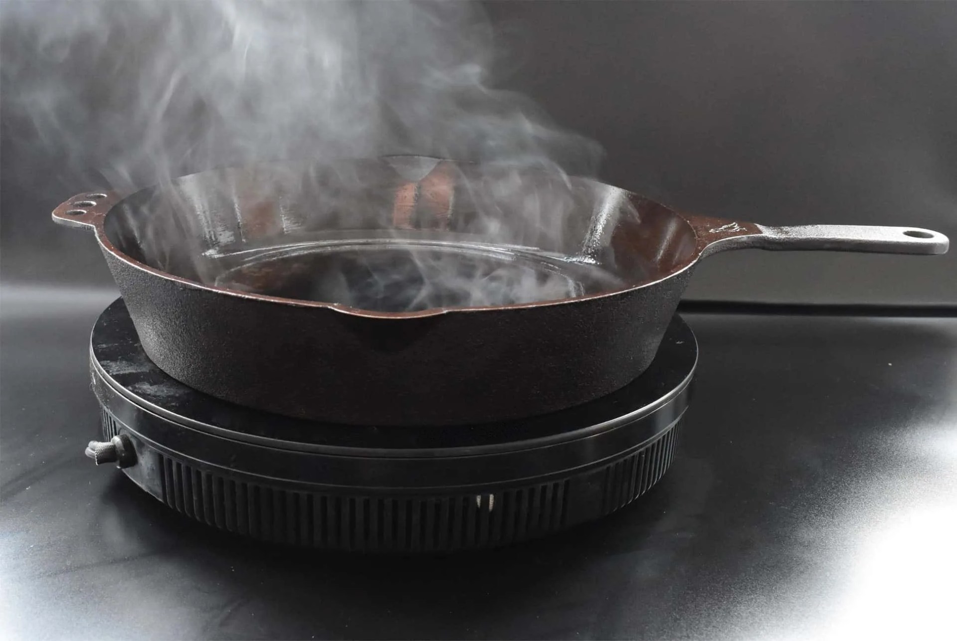 a cast iron skillet smoking on a hot plate
