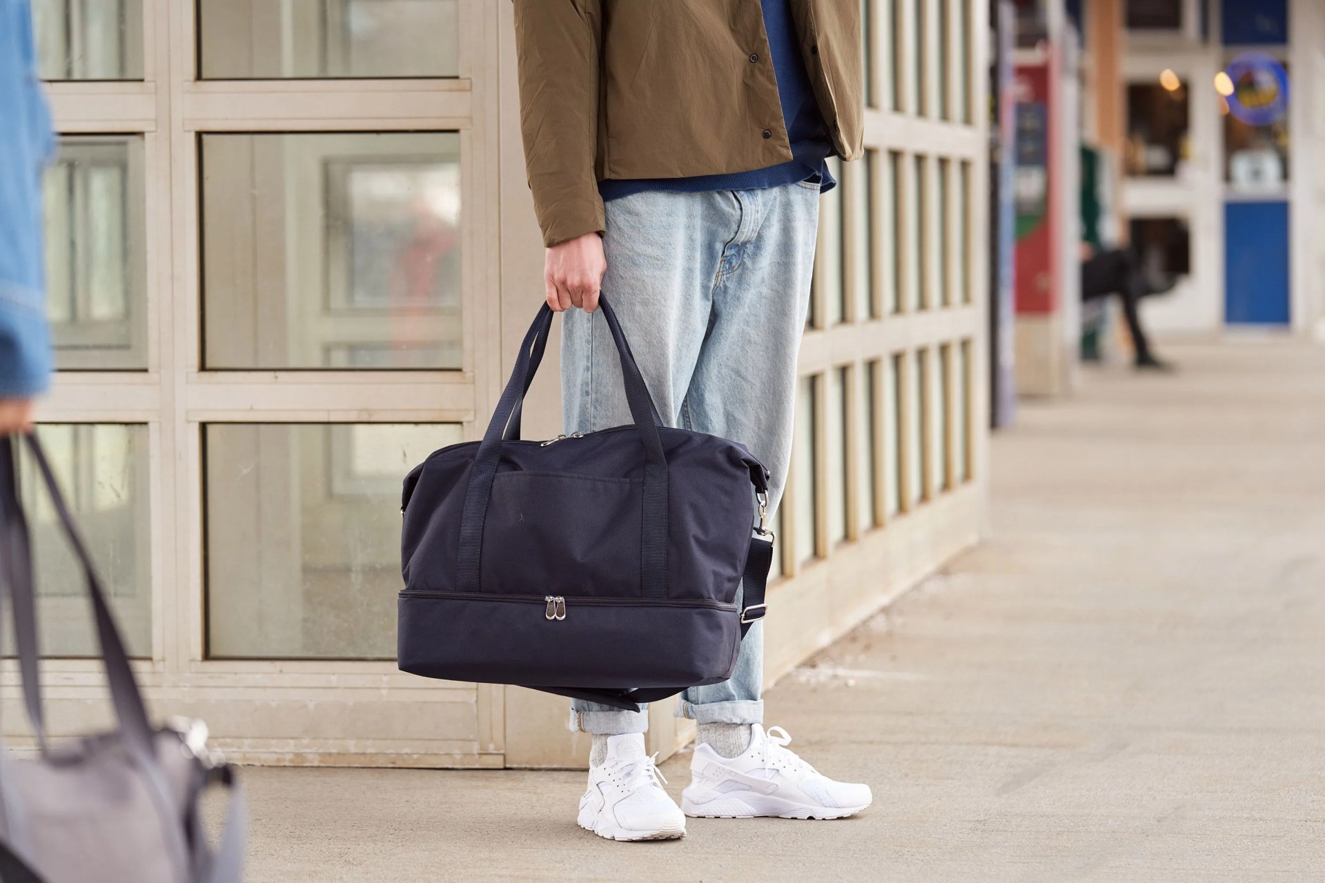 lo and sons man holding weekender bag