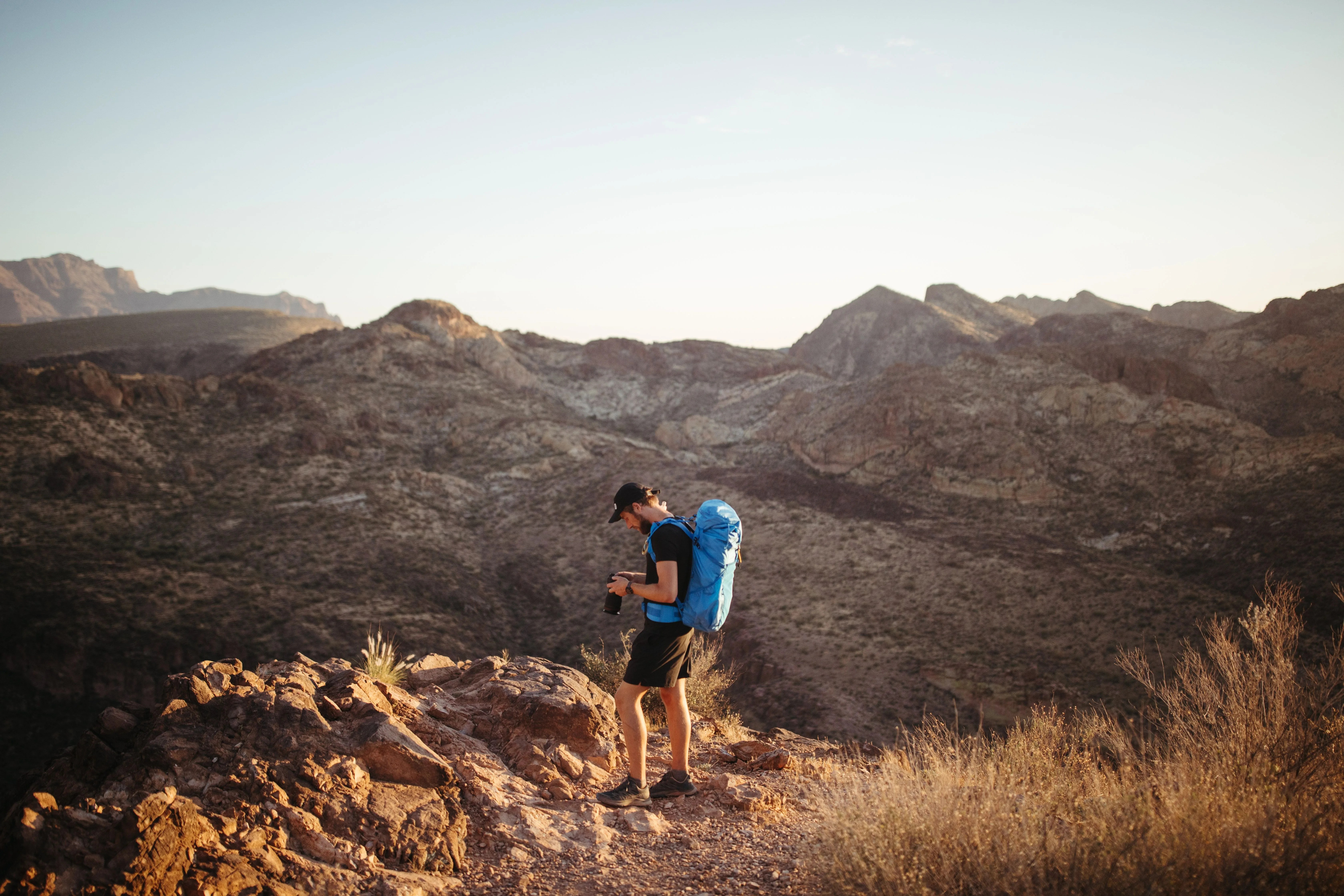 a man with a blue backpack in the desert