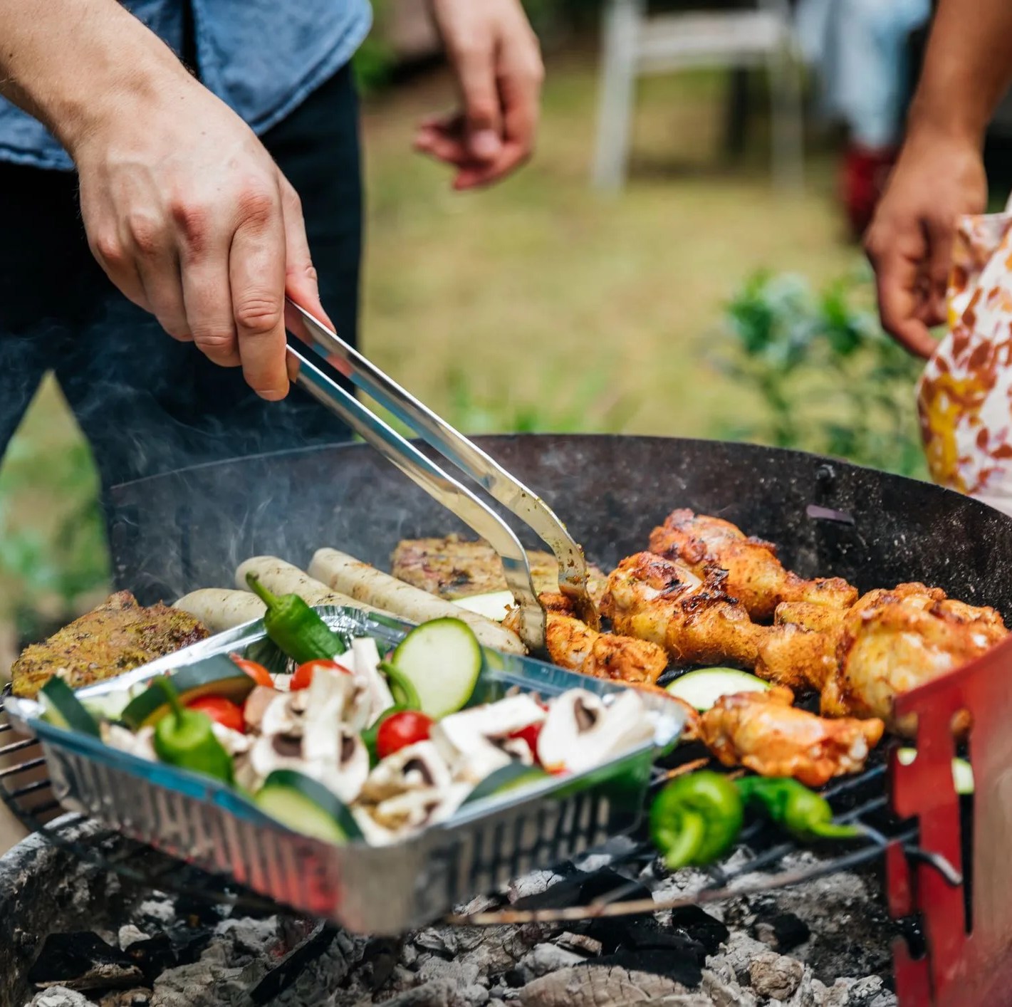 close up of man cooking food on bbq