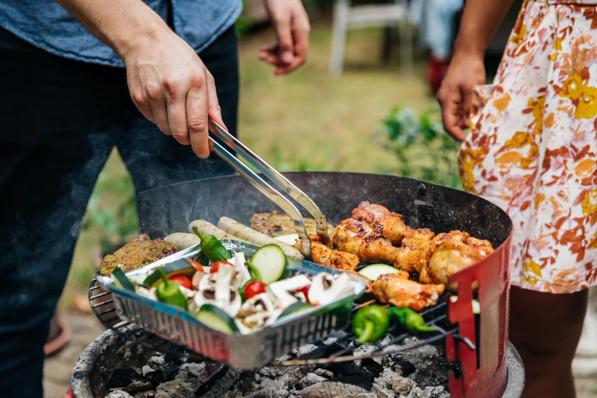 close up of man cooking food on bbq