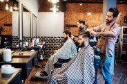 hairdressers cutting hair of clients in salon