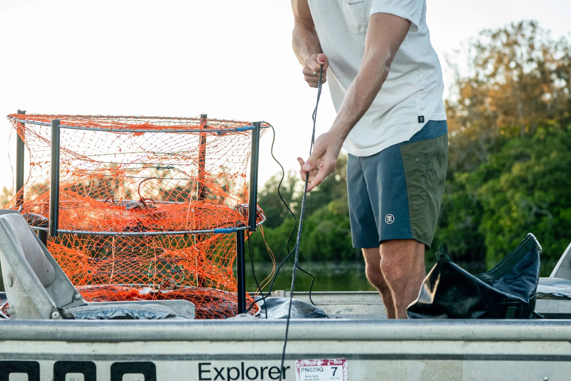 man wearing roark boatman boardshorts standing in boat fishing